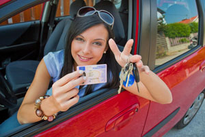 Junge Person sitzt im roten Auto
